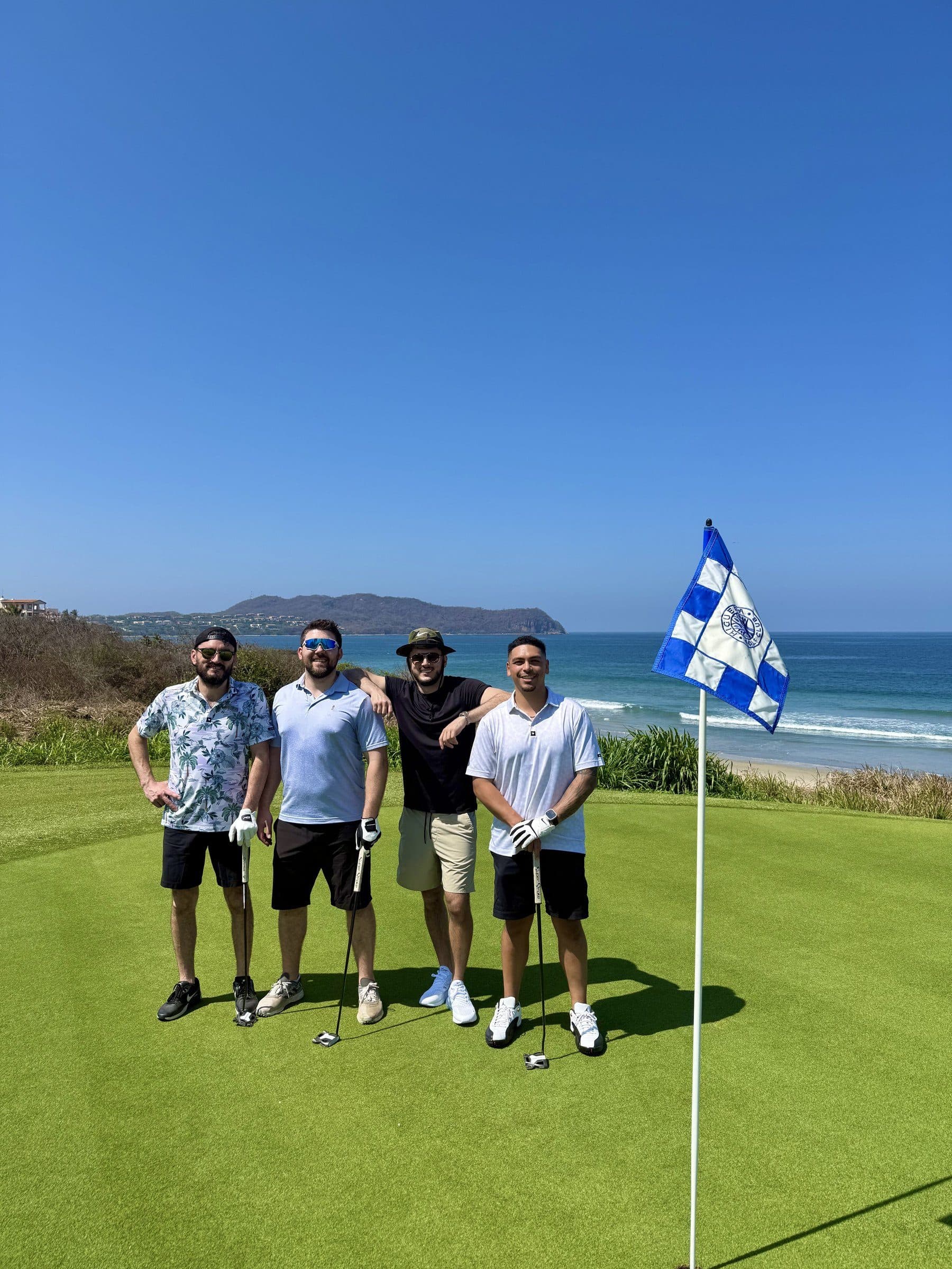 Golf group beside a coastal course flag