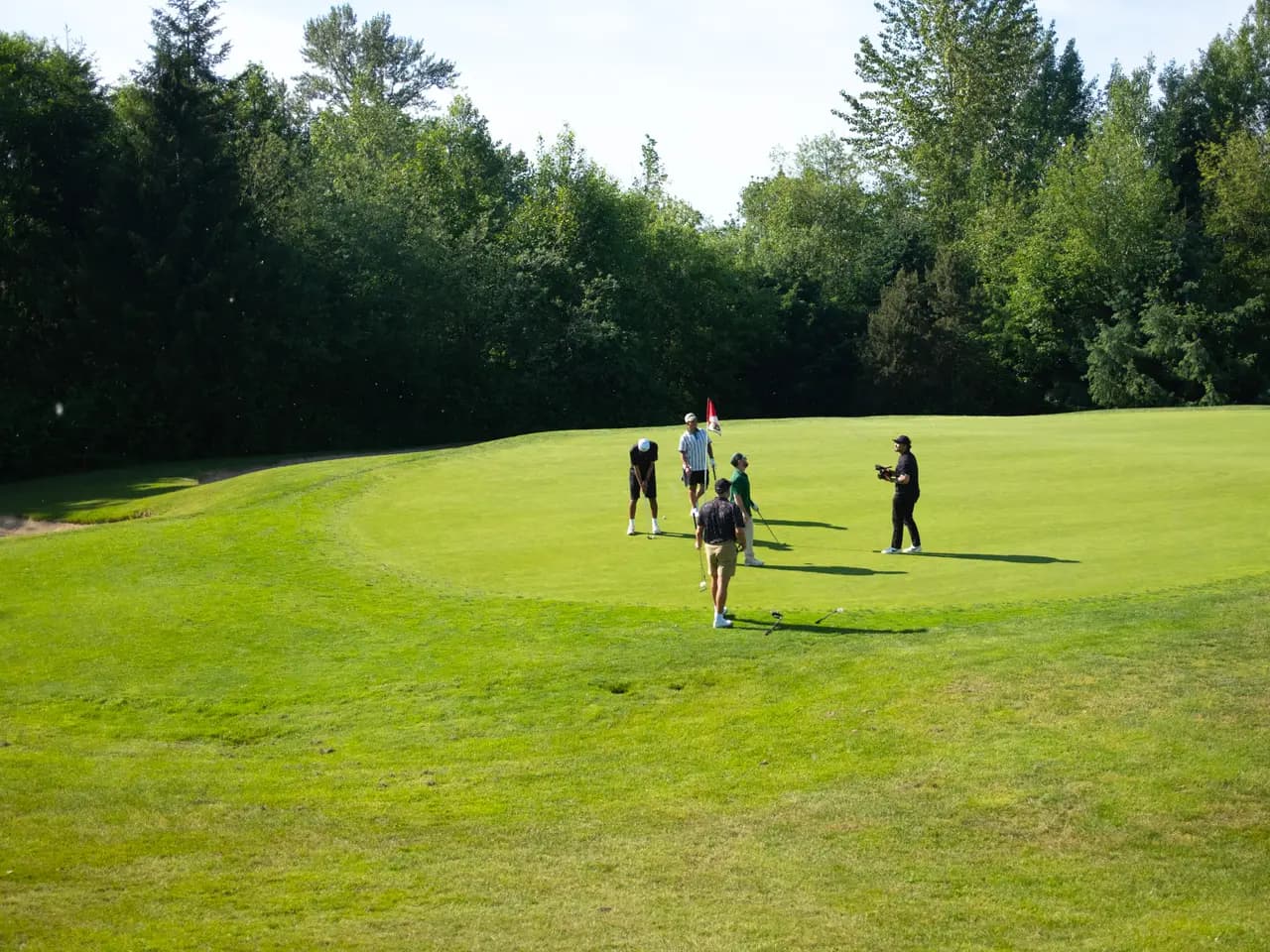 A foursome finishing out a hole together on the green