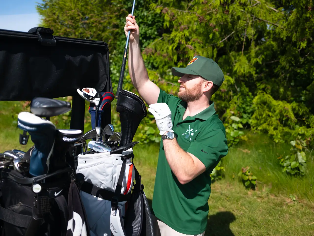 An 18 Holes to Home host pulling a driver from the bag between holes