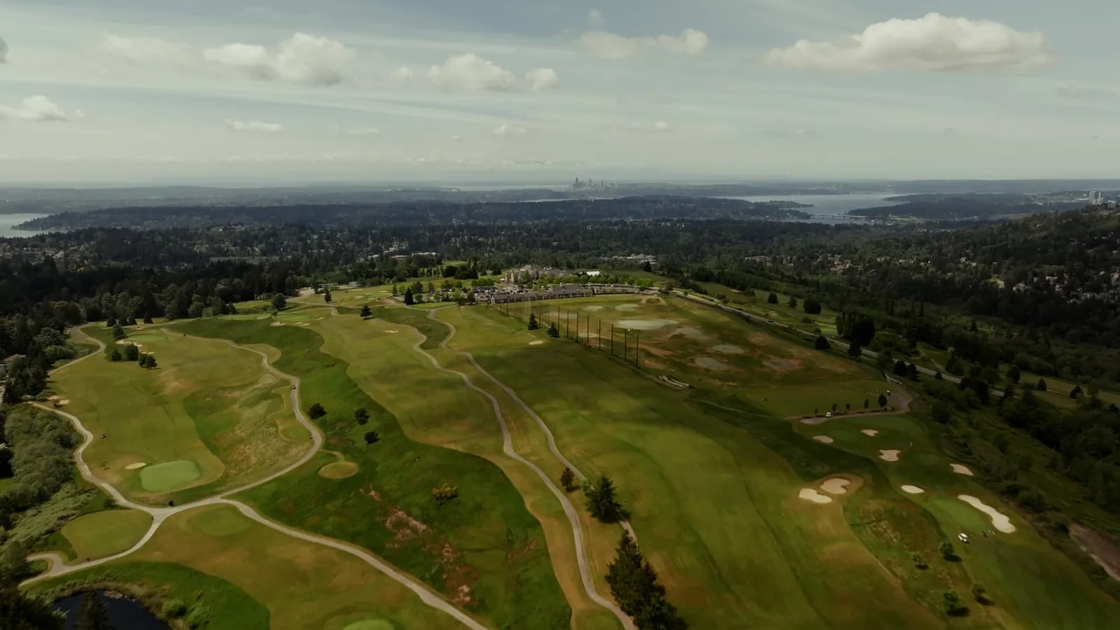 An aerial view of fairways, greens, and surrounding Pacific Northwest neighborhoods