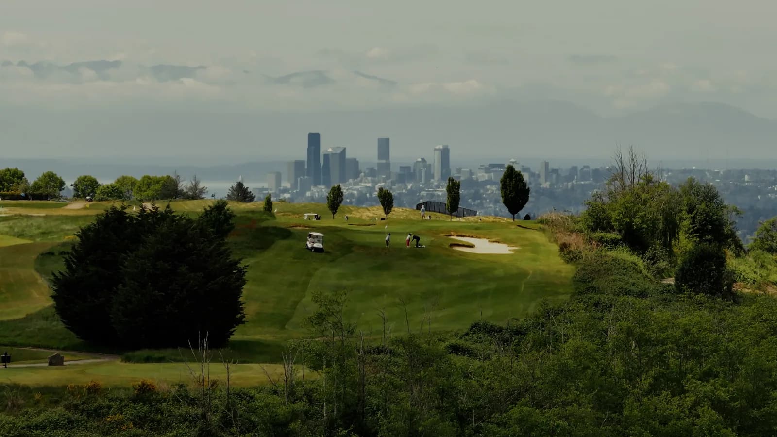 A Pacific Northwest golf green with the Seattle skyline in the distance