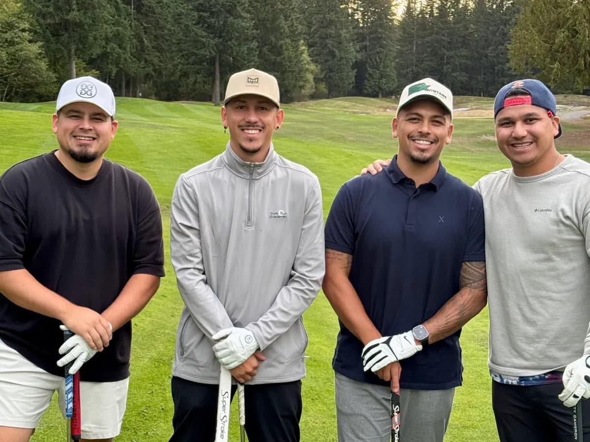 Four golfers posing together on a green fairway